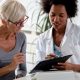 Patient and doctor talking over clipboard