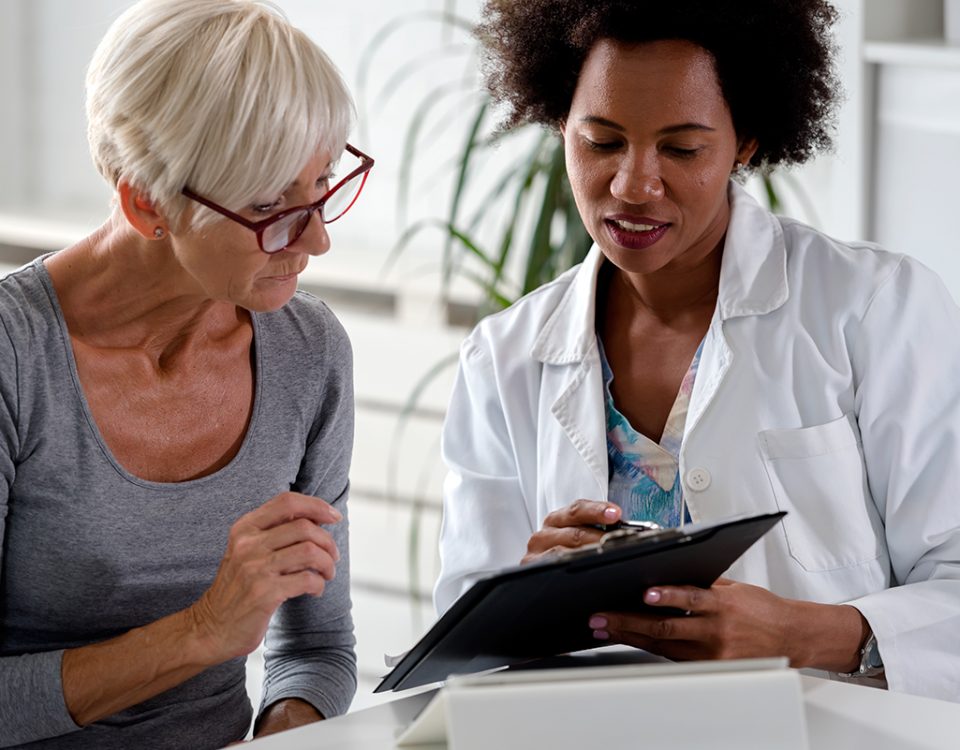 Patient and doctor talking over clipboard