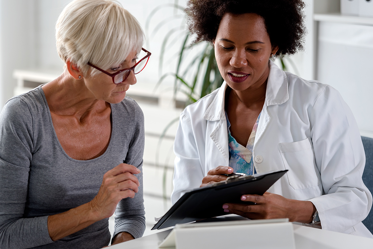 Patient and doctor talking over clipboard