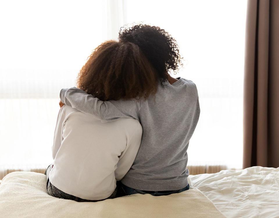 Two black women embrace