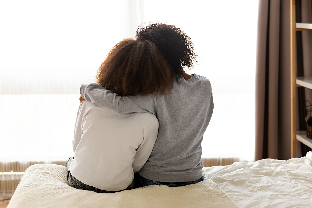 Two black women embrace