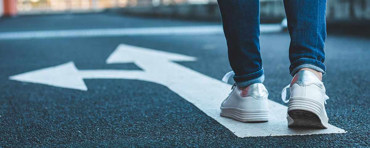 Person walking on directional sign