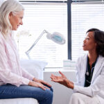 Patient on exam table talking to doctor