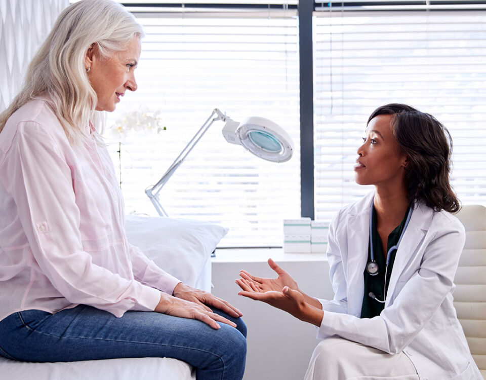 Patient on exam table talking to doctor